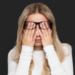 Adult rubbing eyes during evening hours due to cortisol inversion and difficulty winding down at night.